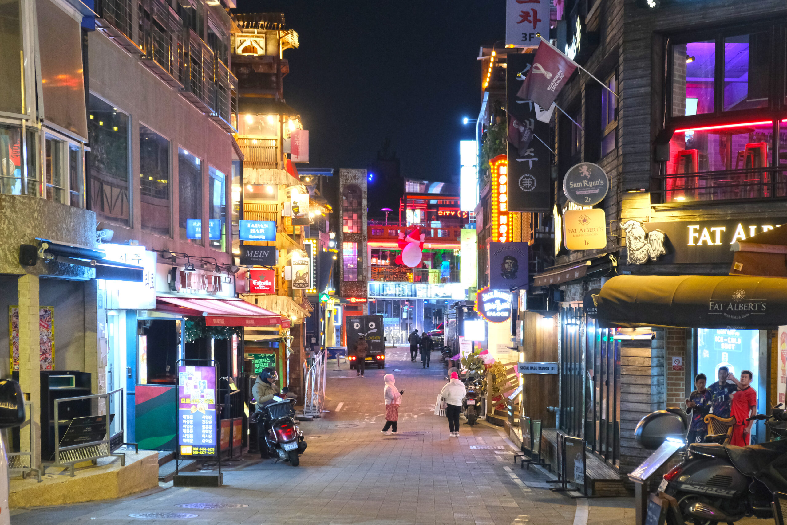 Bars and restaurants lit up in a Seoul nightlife district after dark