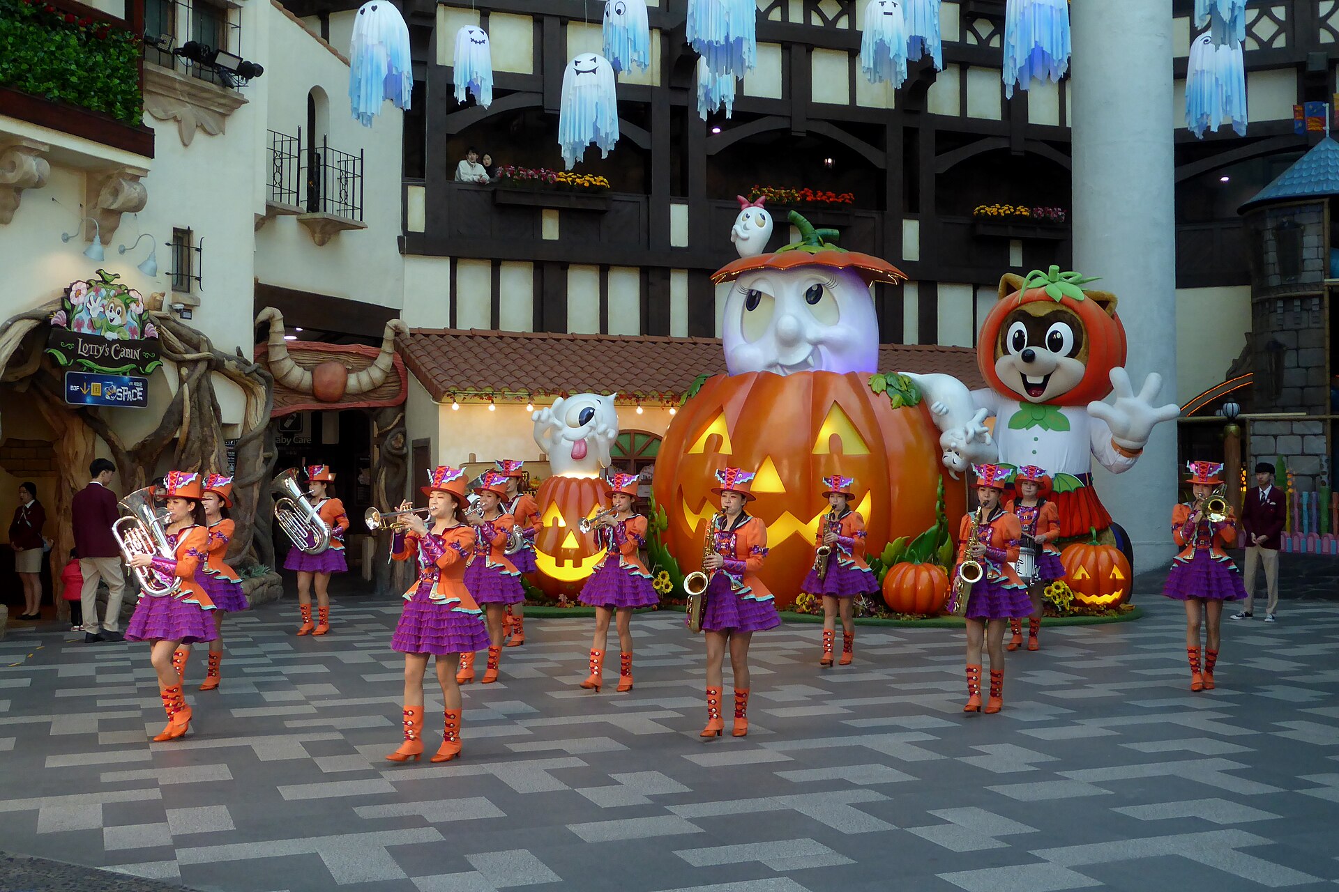 Halloween Korea theme park scene with a marching band and giant pumpkin ghost decorations at Lotte World in Seoul