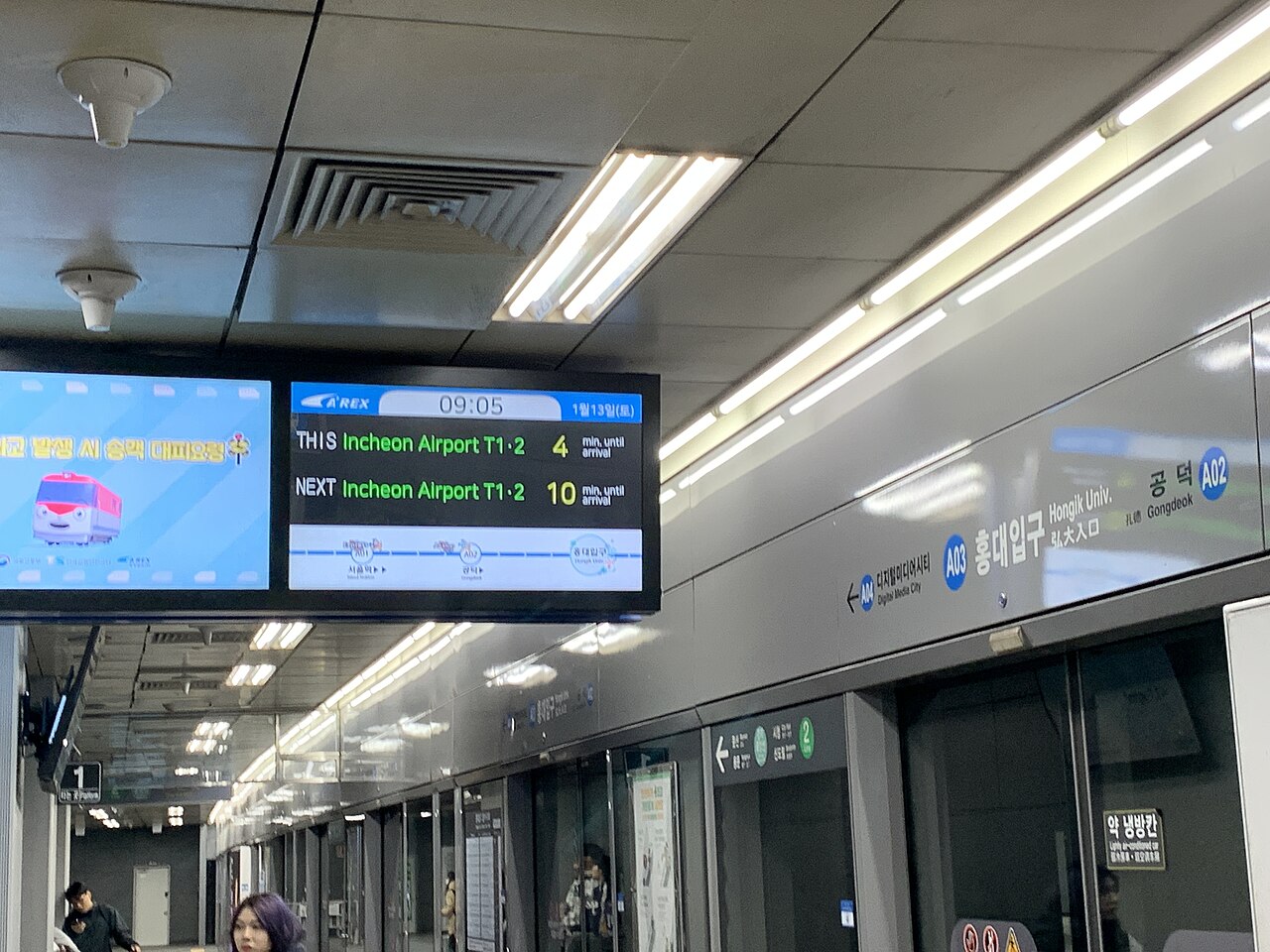 Hongik University Station AREX platform display showing the next trains to Incheon Airport T1 and T2