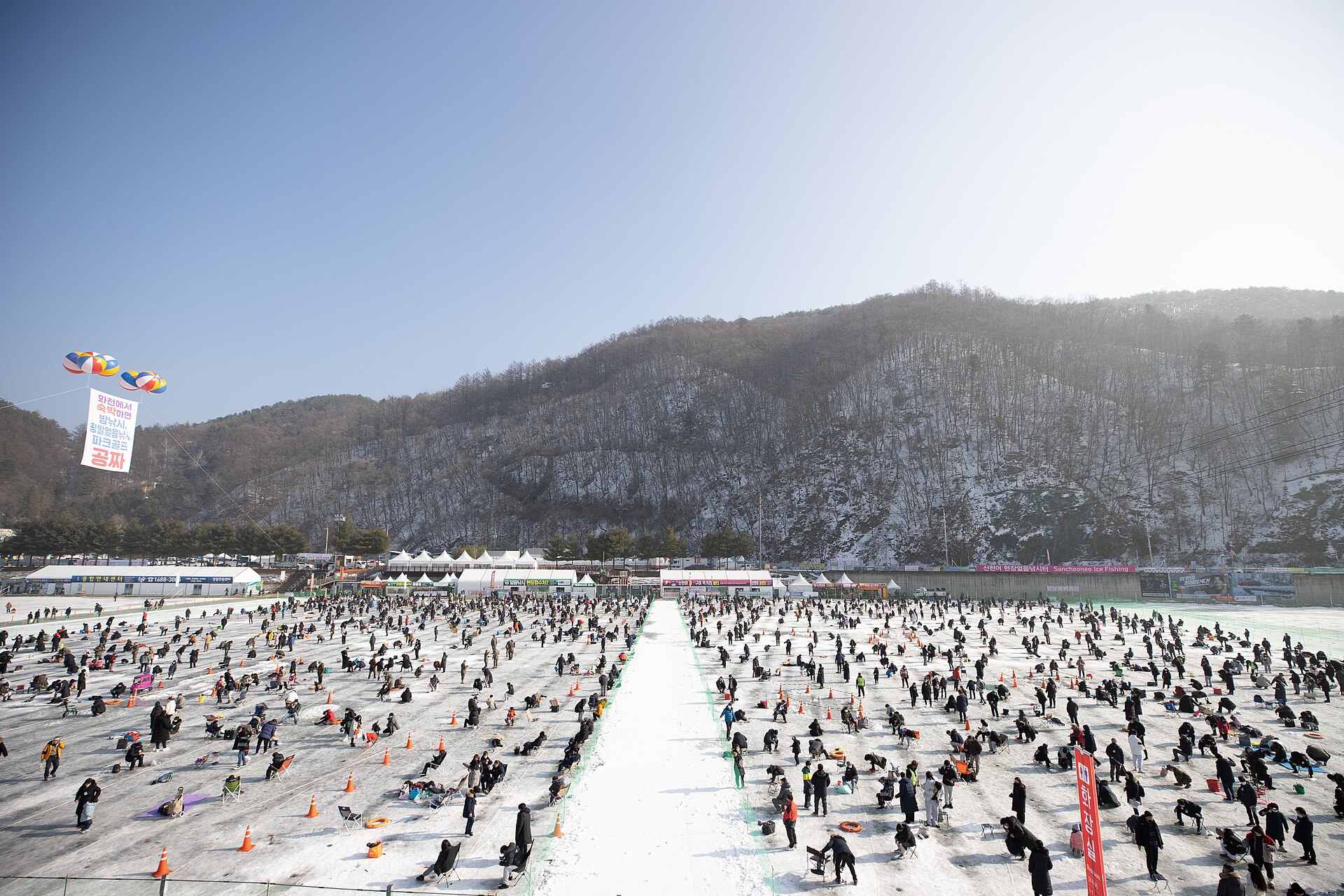 Crowds ice fishing for sancheoneo mountain trout on the frozen river at the Hwacheon Sancheoneo festival