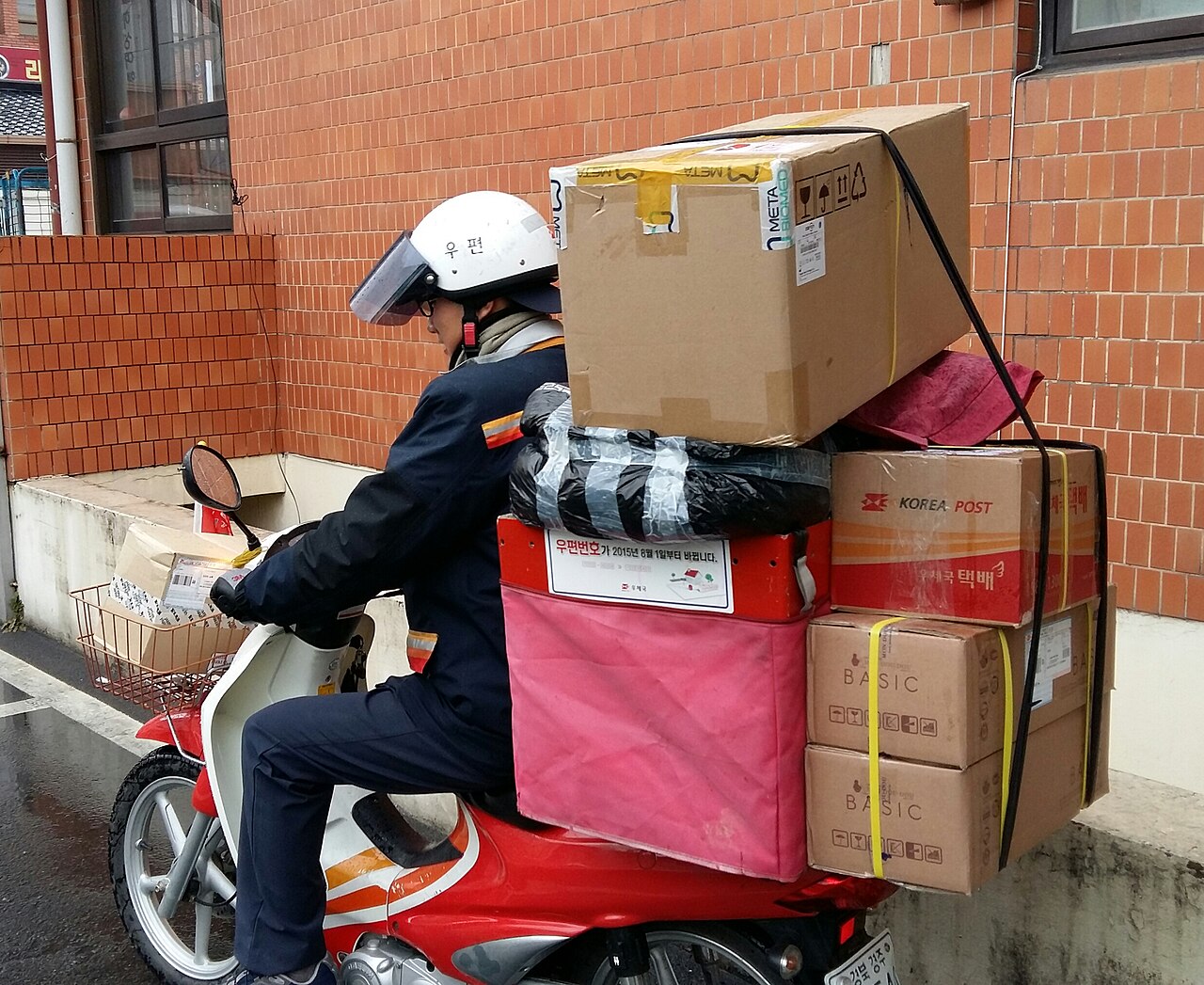 Delivery rider on a motorcycle carrying parcels in Korea