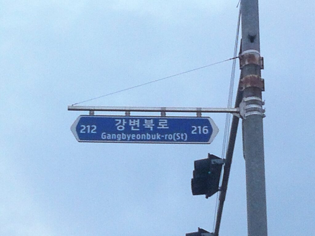 Korean road name sign for Gangbyeonbuk-ro showing the building number range 212 to 216
