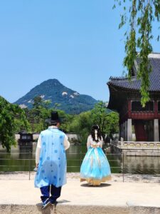 Korean wedding photoshoot idea: couple in hanbok beside the pond at Gyeongbokgung Palace in Seoul