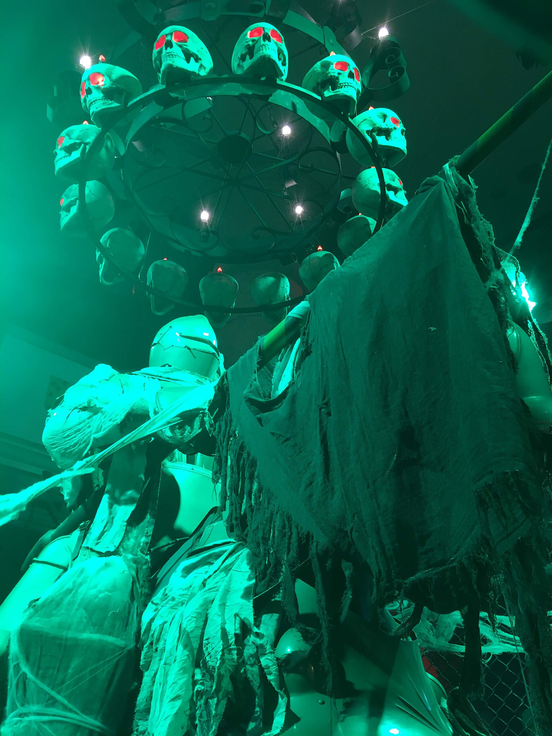 Skull chandelier and shrouded figures in the haunted house at Lotte World