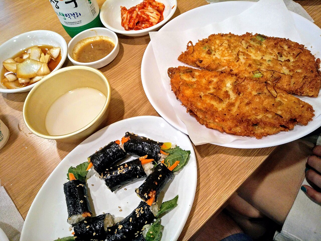 Mayak kimbap, mini seaweed rice rolls, served with bindae-tteok mung bean pancake at a Seoul market